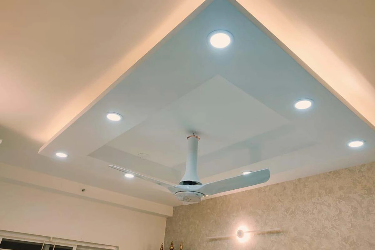 Modern master bedroom interior in Chennai featuring warm tones, ambient lighting, and custom wardrobes.